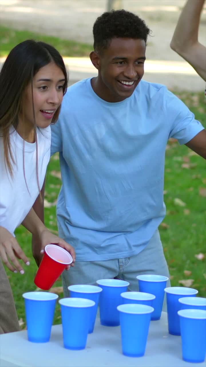 Friends playing beer pong in the park