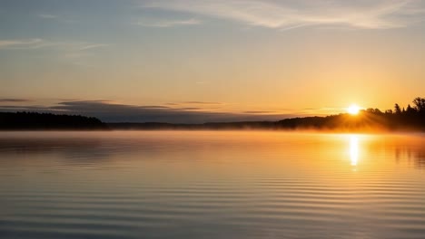 A Serene Sunrise Over the Calm Water: Captivating Beauty of Dawn Reflected in Misty Lake at Daybreak