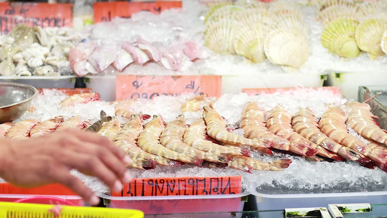 vendedor arreglando camarones en el mercado de mariscos de phuket
