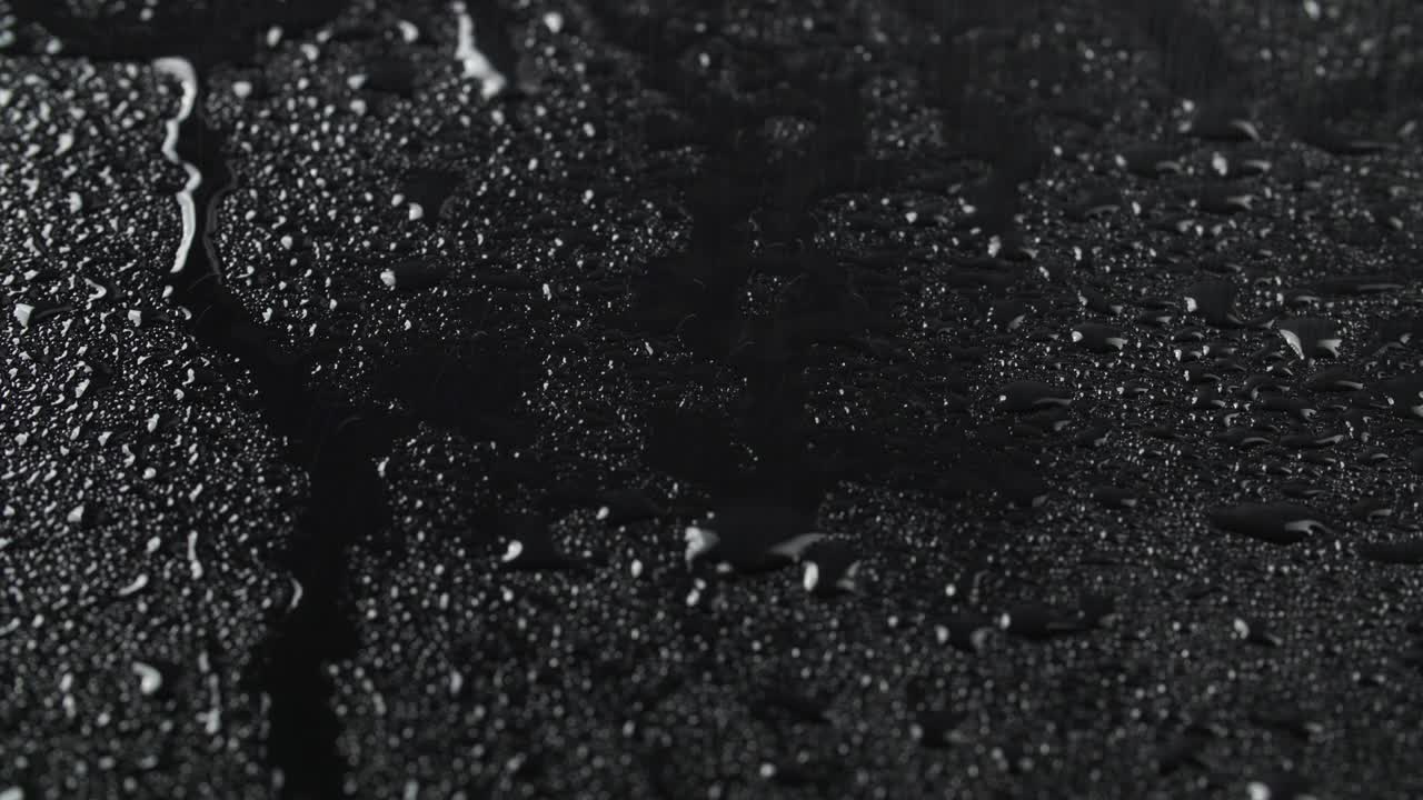 video de gotas de lluvia sobre un fondo de vidrio negro