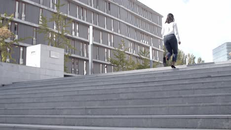 una joven mujer de negocios morena subiendo las escaleras