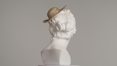 white marble bust with straw hat