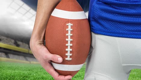 animation of midsection of rugby player holding ball over sports stadium