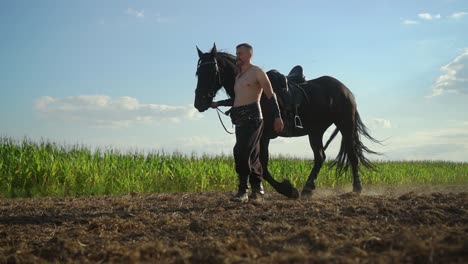 a man walks with a horse in the field 07