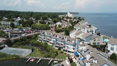 chesapeake beach bay, maryland usa, drone aerial view of upscale condo buildings, marina and city traffic on summer day