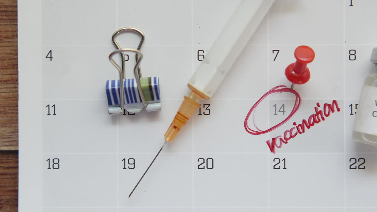 ampolla de vidrio con vacuna y jeringa en el calendario