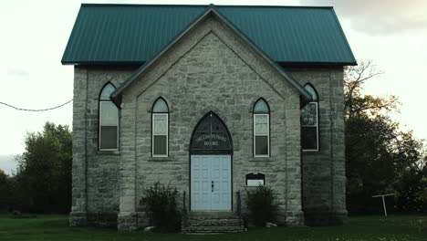 exterior of an old stone church with a green roof