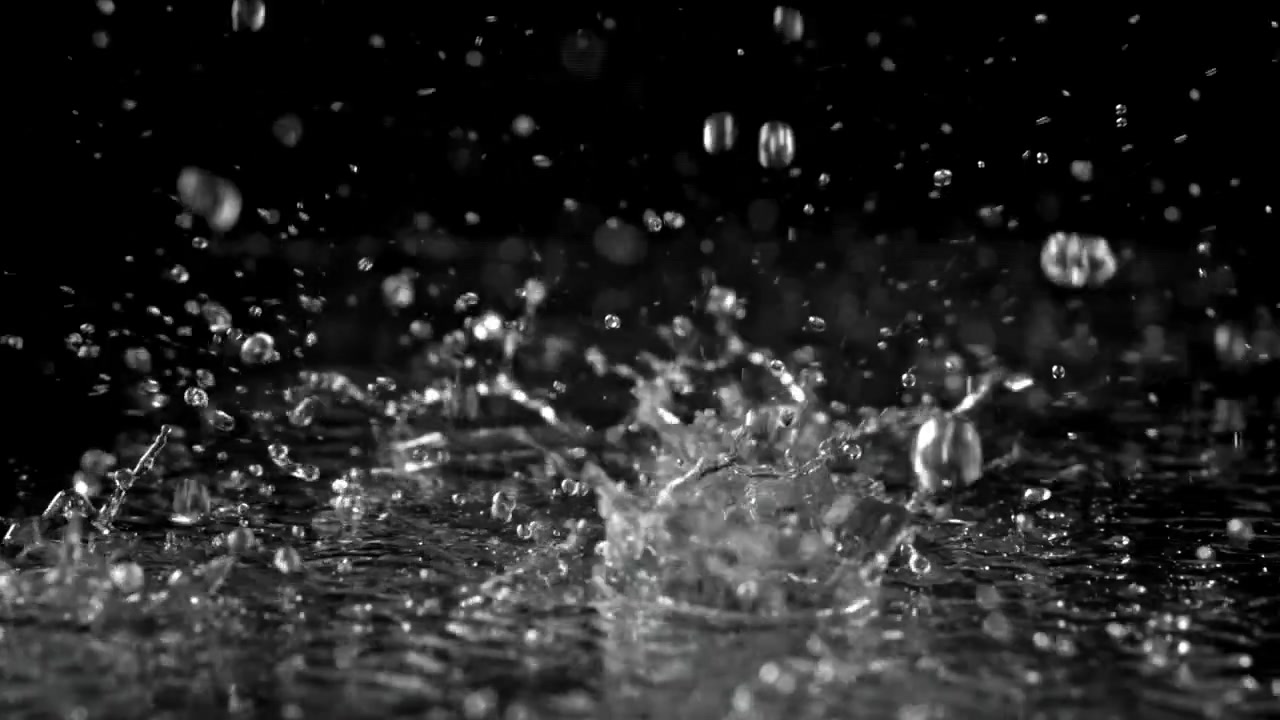 Slow Motion Rain Drops Splashing on Black Surface