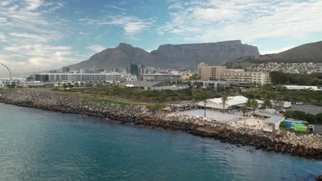 view of iconic table mountain behind cape town, filmed from water by drone