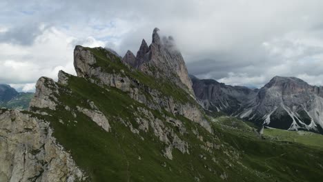 seceda mountains in the italian dolomites with the clouds covering the steep pinnacle shaped cliffs