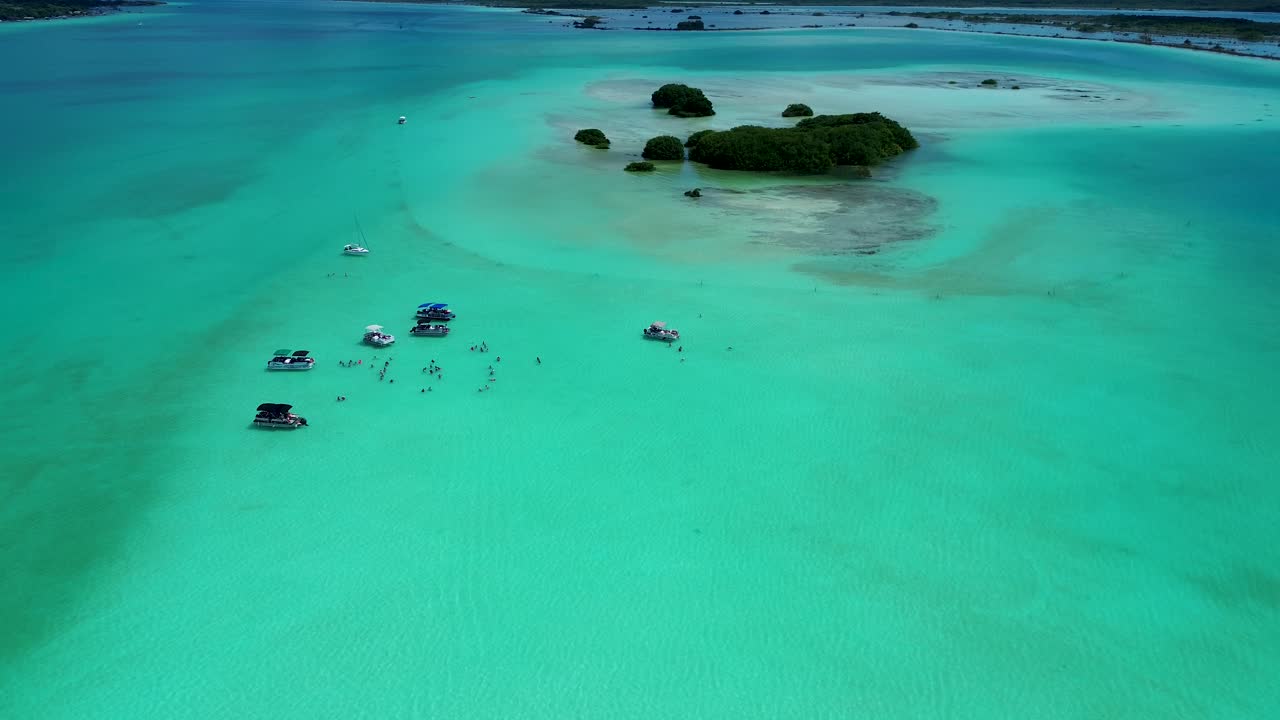 Drone aerial landscape of tour motorboats cruises with tourists people swimming in bay lagoon lake channel inlet on sandbar Bacalar Mexico Central America holidays travel