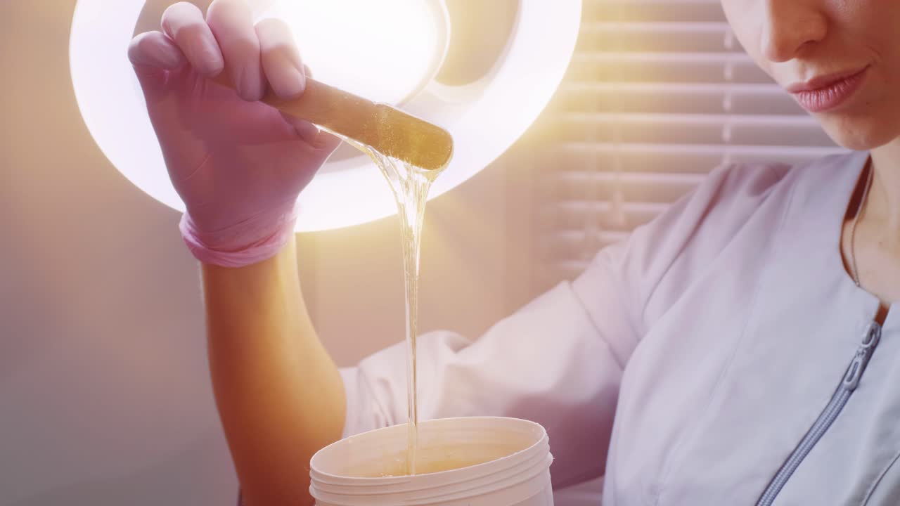 설탕 머리카락을 들고 있는 여성 페이스트를 제거합니다. 아름다움 개념. 설탕. 탈모 과정.