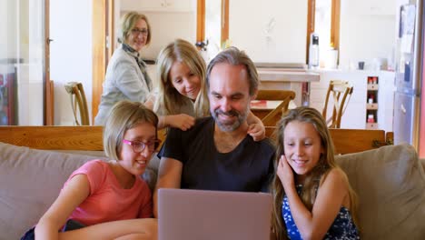 father and daughters using laptop in living room 4k