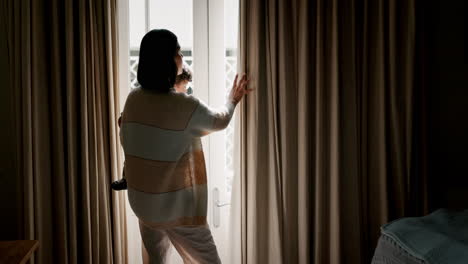 ventana, el hogar y la madre con el bebé apuntando