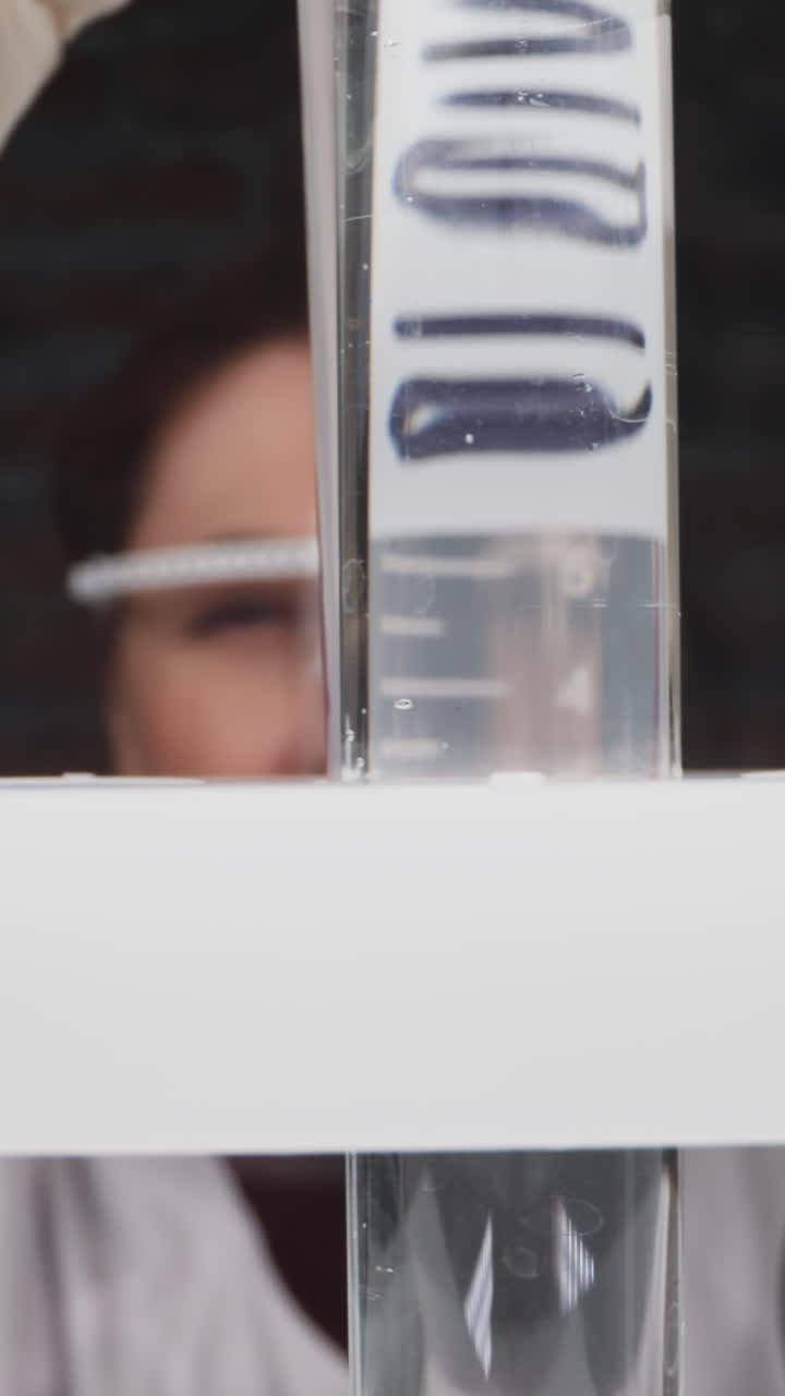 Female researcher works with patient blood sample in graduated tube with word Covid slow motion. Probe lens footage of medicine examination macro view