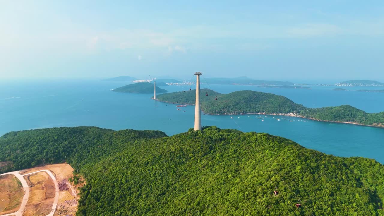 World's longest three-rope cable car stretching over lush green islands in Phu Quoc, Vietnam. Towering pylons rise above the scenic coastline and turquoise waters.