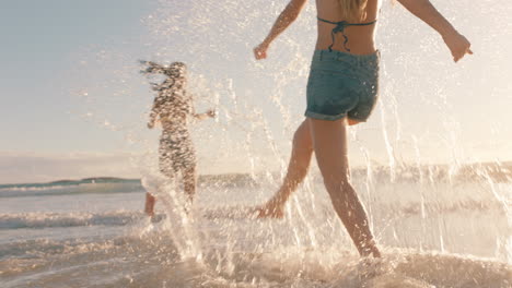 Dos-Mujeres-En-La-Playa-Salpicándose-Agua-De-Mar-Divirtiéndose-Adolescentes-Jugando-En-Un-Cálido-Día-De-Verano-Junto-Al-Océano-Disfrutando-De-Las-Vacaciones-De-Verano