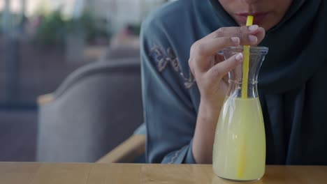 woman drinking lemonade in a cafe