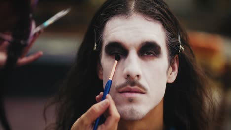 makeup artist applying halloween face paint