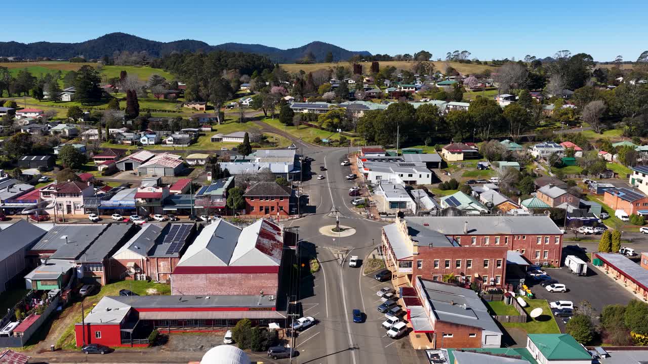 Drone ascends above Dorrigo, revealing rural town center, roads, shops, and surrounding countryside