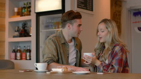 young couple interacting with each other in cafe 4k