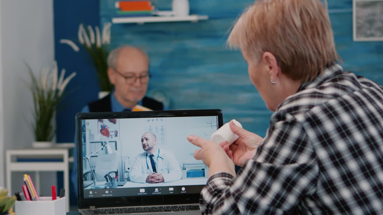 Donna in pensione che parla in una sessione di telemedicina tramite internet con un giovane medico