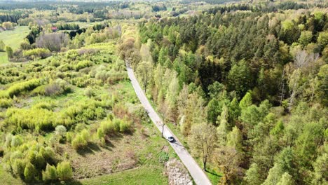 Ein-Auto,-Das-Auf-Einer-Von-Grünen-Bäumen-Umgebenen-Straße-Fährt