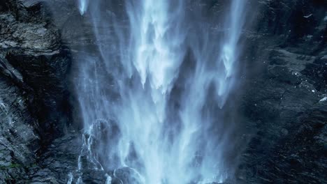 aerial top down shot of falling water downhill mountain in wilderness of norway- beautiful peaceful waterfall in norwegian mountains