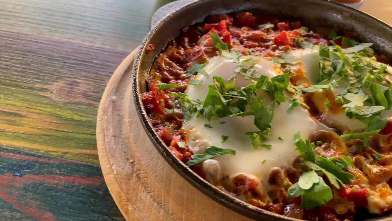 vista de cerca de la tradicional shakshouka, huevos asados en salsa de tomate, aceite de oliva, pimientos, cebolla y ajo, baja cantidad de carbohidratos, comida keto.