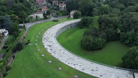 talponia, the semi-subterranean residential unit in ivrea, piedmont, designed by gabetti isola in 1968, set in a curved green park at the city forest edge, drone pull away shot slow motion, italy