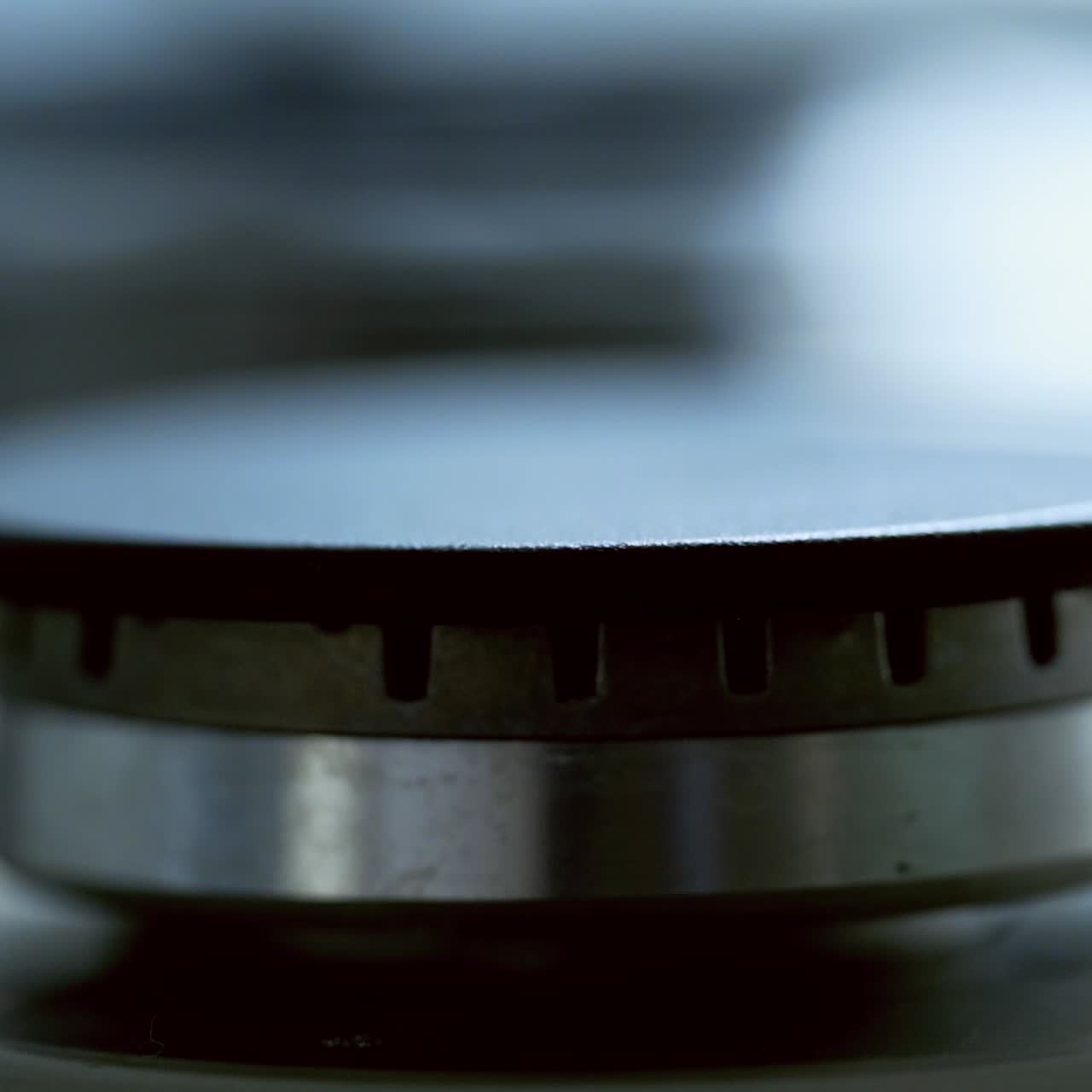 Kitchen burner turning off. Blue flame on a stove side burner. Natural gas stops burning. Close-up.