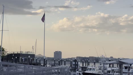 american flag waving in the wind during sunset in the boston harbour