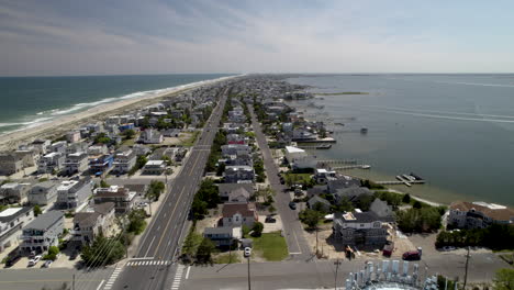 Ciudad-De-Playa-De-Isla-Flaca-Con-Vistas-Tanto-A-La-Bahía-Como-Al-Océano,-Toma-Aérea,-Desde-La-Torre-De-Agua-Hacia-Abajo-De-La-Isla