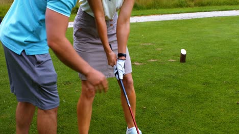 Männlicher-Lehrer,-Der-Frau-Beim-Golflernen-Unterstützt