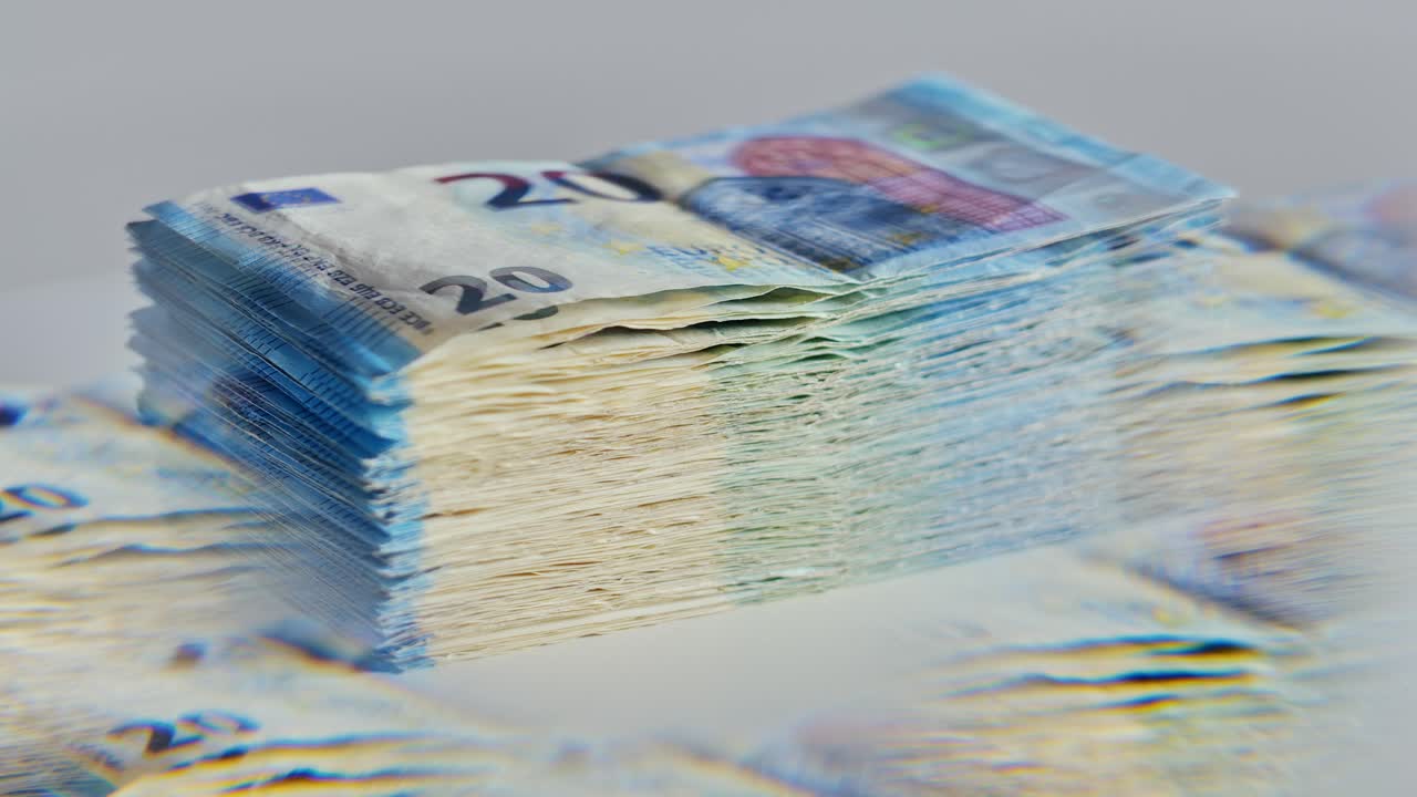 Slow motion of 20 euro bills spinning through five-sided glass prism reflection