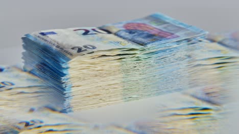 slow motion of 20 euro bills spinning through five-sided glass prism reflection