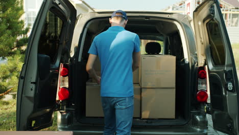 delivery person loading boxes into van