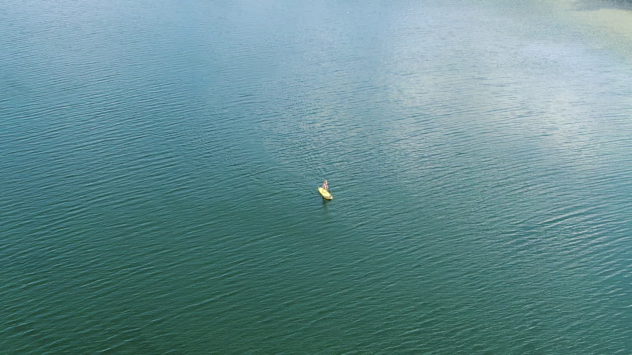 persona solitaria remando en el vasto lago lituano, vista aérea de drones