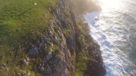 cinemática de acción aérea sobrevolando a los surfistas surfeando en coffee bay en sudáfrica