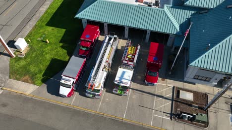 Overhead-aerial-shot-of-firetrucks-and-ambulances-parked-in-front-of-a-fire-station