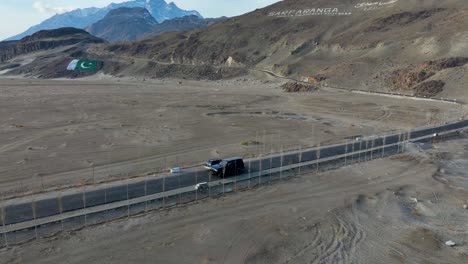 Vista-Lateral-De-Vehículos-Que-Pasan-Por-Carreteras-Suburbanas-Del-Frío-Desierto-De-Sarfaranga---Valle-De-Skardu-Durante-El-Día-En-Pakistán