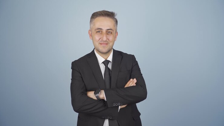 Uomo d'affari a braccia conserte che ride alla telecamera