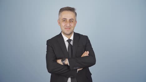 hombre de negocios con los brazos cruzados y riéndose de la cámara.
