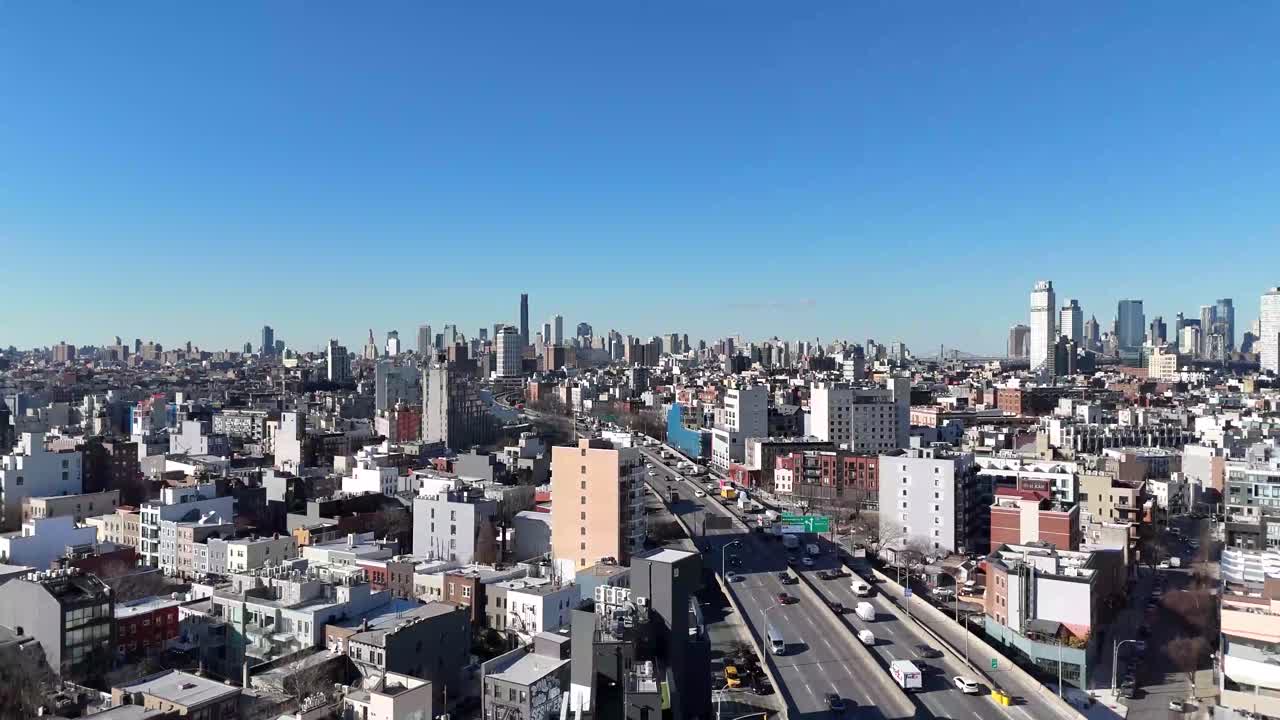 Horizontal drone ascending shot over Withers Street in Brooklyn, capturing the city's vibrant streets, residential rooftops, and dynamic skyline as the camera smoothly rises.