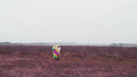 person preparing for paragliding in a field