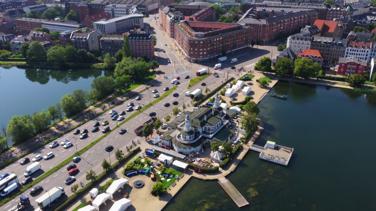 Aerial drone view of the Lakes in Copenhagen, Denmark, showing the urban waterfront, historic apartment buildings, tree-lined streets, and city infrastructure