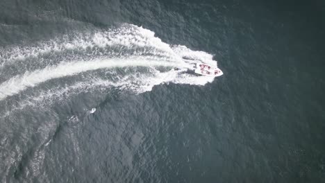 Top-down-shot-of-friends-on-a-boat-wakeboarding-in-the-summer