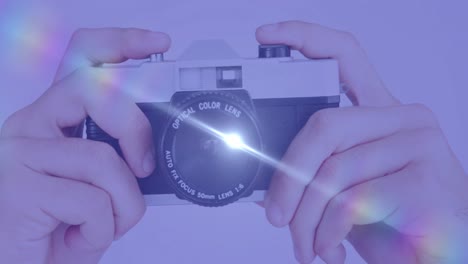 디지털 카메라를 들고 있는 손의 클로즈업에 대한 빛의 반점