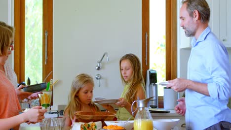 Family-having-meal-in-kitchen-4k
