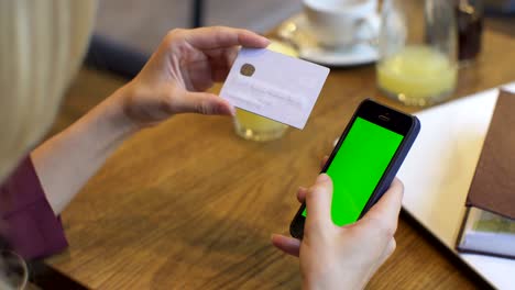 compras en línea. mujer de negocios con una tarjeta de crédito de oro en la mano y compras en internet. pantalla verde, llave de croma